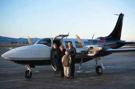 Gary Young with family standing next to an airplane