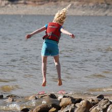 child jumping near water